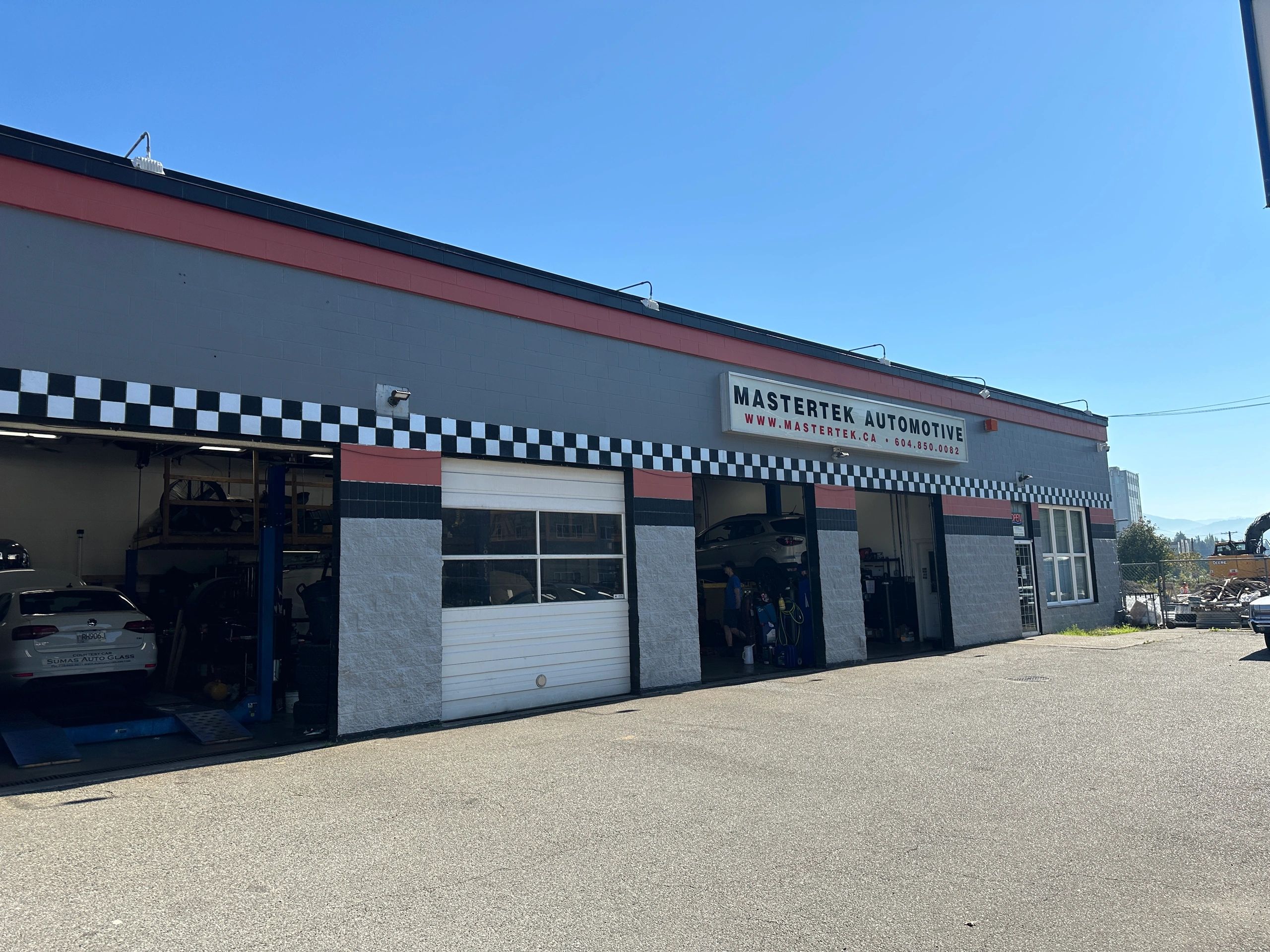 Mastertek Automotive repair shop exterior in Abbotsford with black and white checkered storefront design and multiple service bays