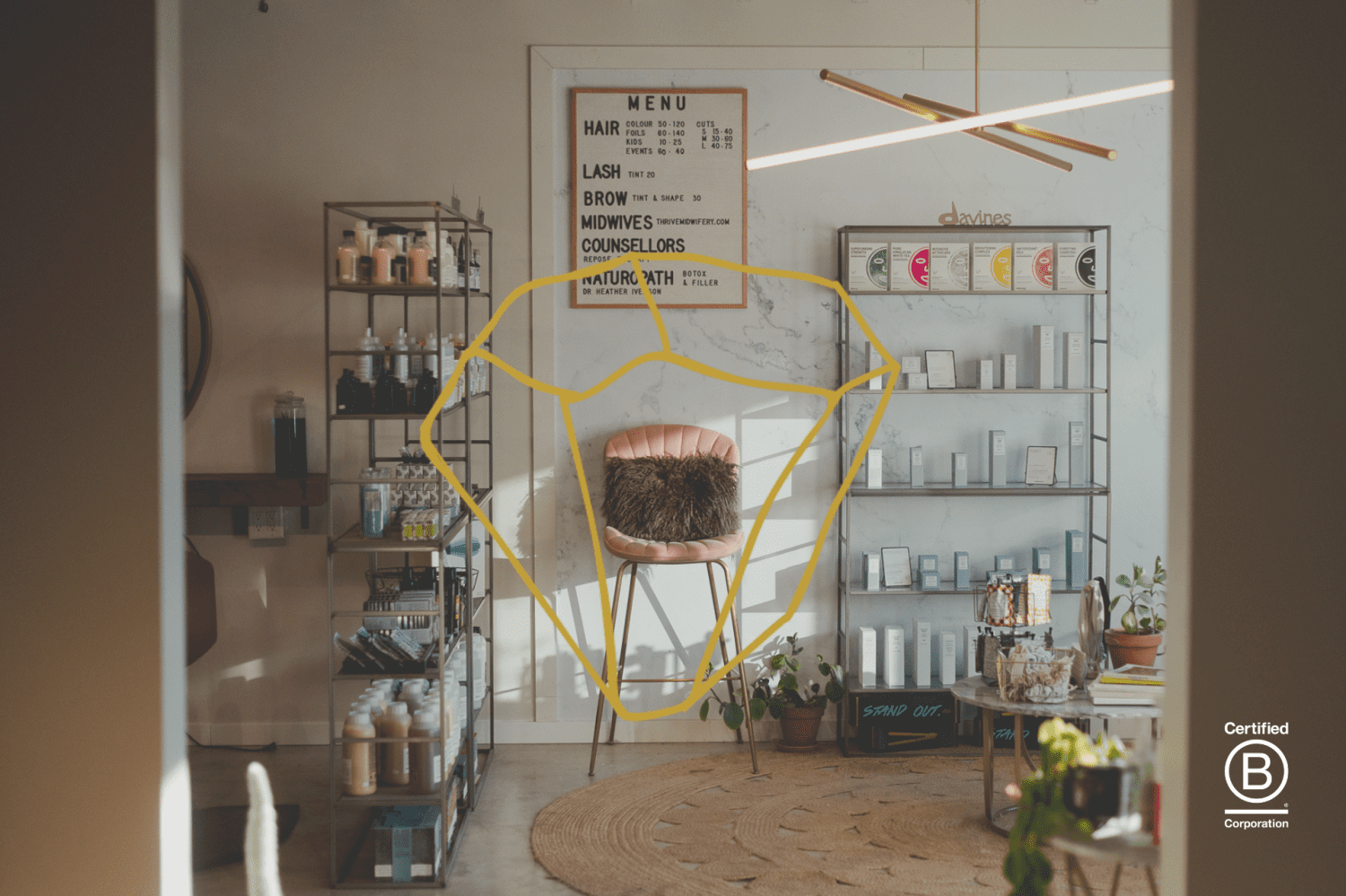 Modern beauty salon interior in Abbotsford featuring a yellow neon sign above a woven chair, metal shelving with beauty products, and a service menu on the wall