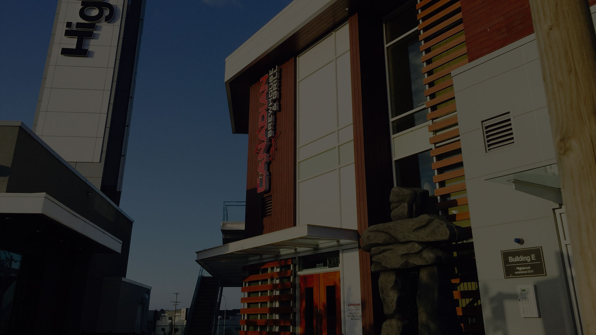 Modern commercial building entrance with red and wood architectural features at The Canadian Brewhouse & Grill in Abbotsford