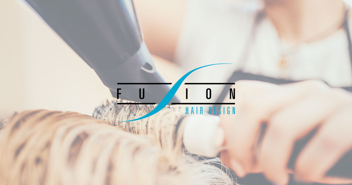 Professional hair styling at Fusion Hair Design salon in Abbotsford, showing stylist using blow dryer on blonde hair