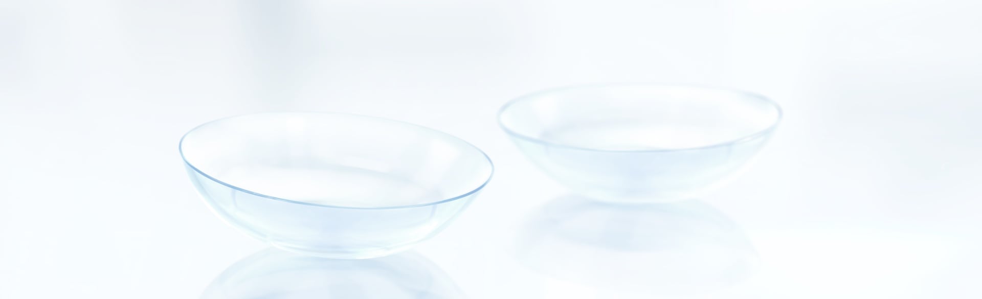 Two clear contact lenses displayed on a white background