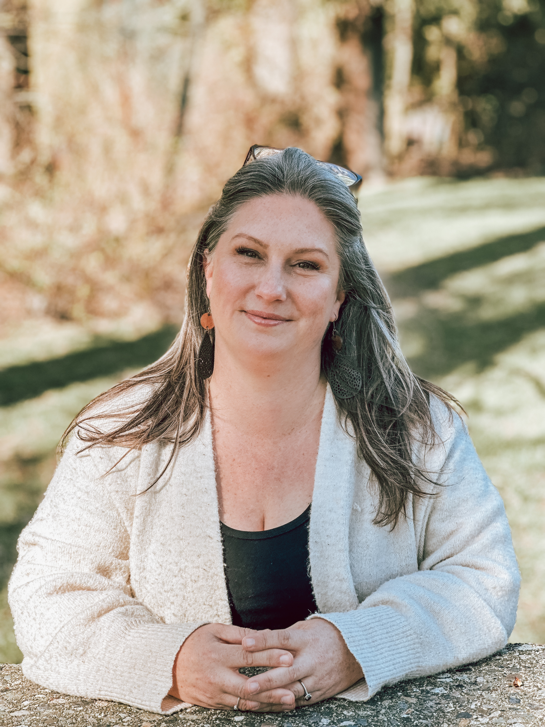 Jamie Gazlay, a counselor at Quintessence Counselling & Supportive Services in Abbotsford, poses for a professional portrait outdoors against a brick wall