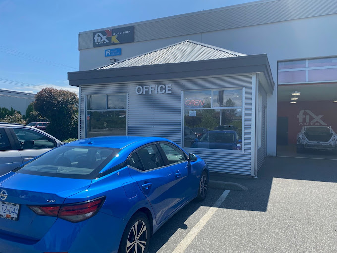 Blue Nissan SV parked in front of FIX Auto Abbotsford West office building with metal roof and large windows on a clear sunny day