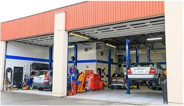 Collins Automotive shop front in Abbotsford with open garage bays showing lift equipment and service vehicles